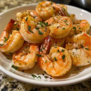 Delicious easy garlic butter shrimp served on a plate with herbs.
