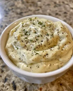 Creamy Garlic Parmesan Sauce in a serving bowl with herbs garnishing