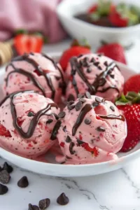 Chocolate strawberry frozen yogurt bites in a bowl topped with fresh fruit