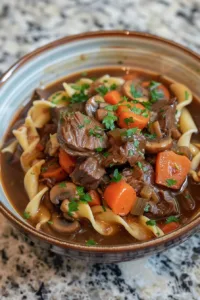 Crock Pot Beef and Noodles dish served in a bowl with herbs