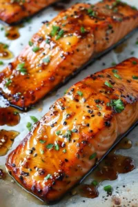 Delicious brown sugar glazed salmon on a plate with garnishes.