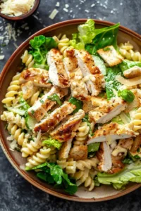 Bowl of Easy Chicken Caesar Pasta Salad with grilled chicken, lettuce, and Caesar dressing