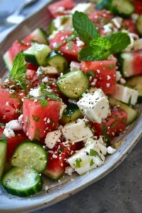 Feta, watermelon, and cucumber salad in a vibrant bowl.