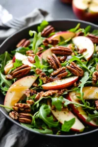 Fresh apple arugula salad topped with maple pecans and a light dressing.