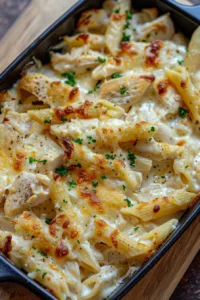 Creamy baked chicken Alfredo dish served in a white bowl with parsley garnish.