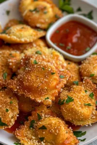 Plate of crispy toasted ravioli served with marinara sauce