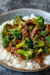 Beef and broccoli stir-fry served with rice in a vibrant dish.