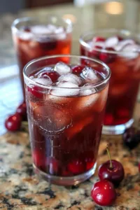 Refreshing Chilled Cherry Iced Tea served in a glass with cherries and ice.