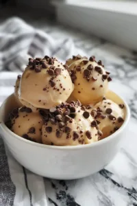 Frozen Greek yogurt peanut butter bites in a bowl garnished with nuts