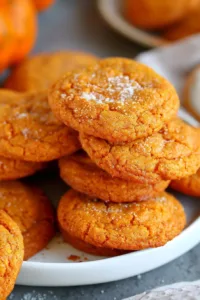 Freshly baked pumpkin cookies on a plate with autumn decor